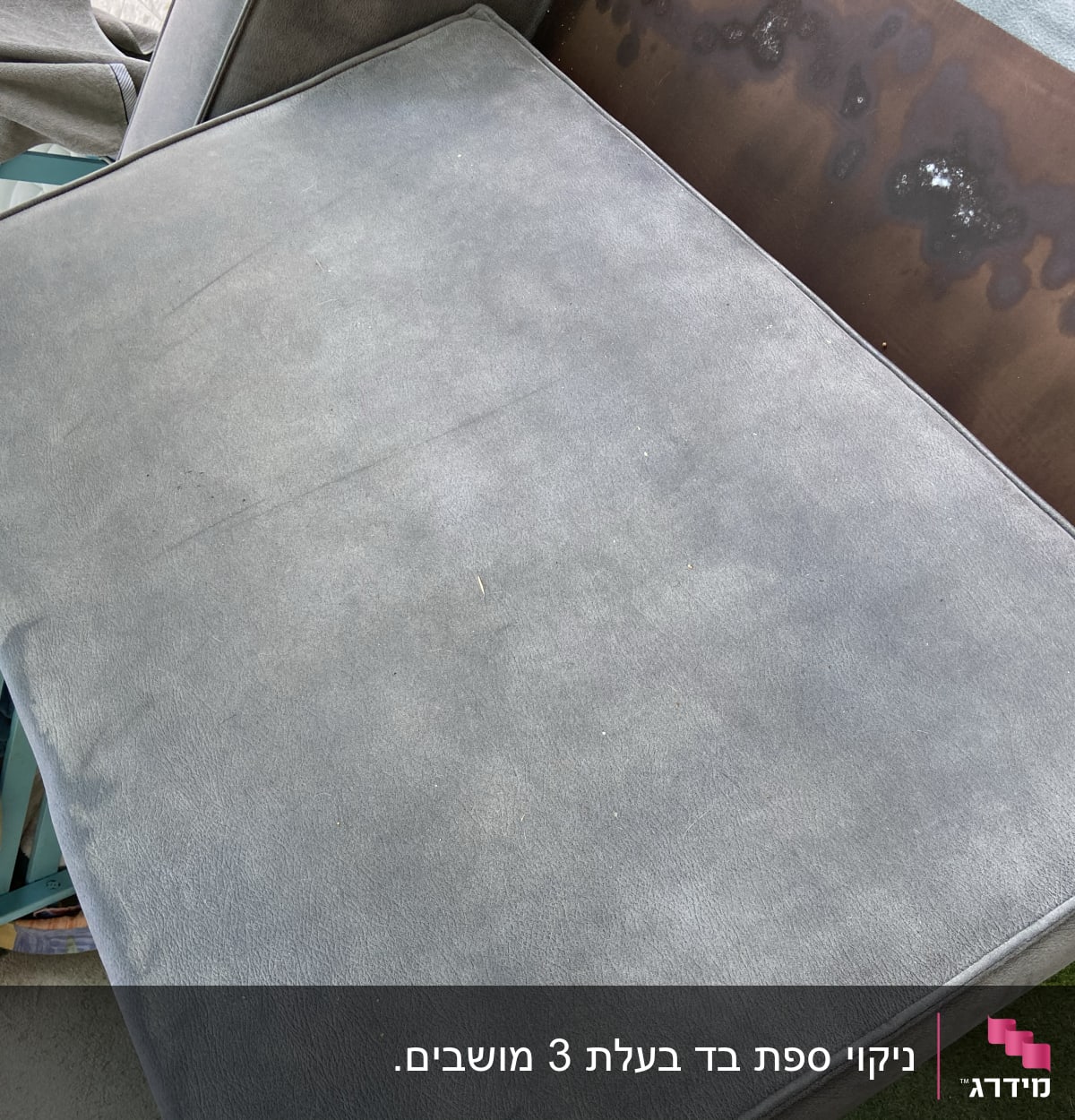 כרית ספה אפורה עם כתמים כהים